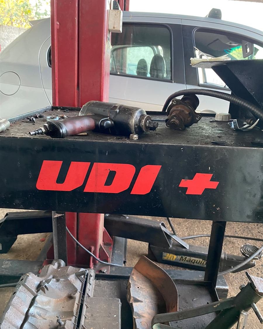 Bancada de elevador da Udi Mais com chaves de impacto e a logo da oficina
